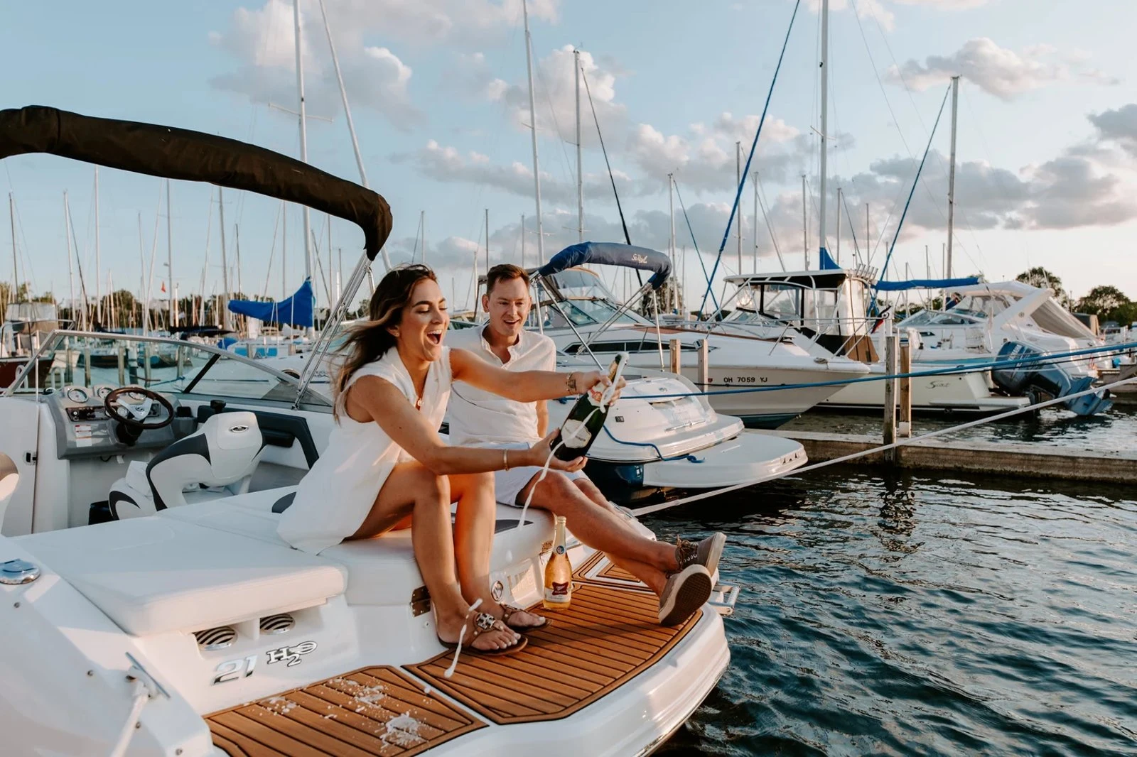 Guests raise glasses aboard a boat in a marina
